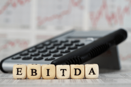 a calculator and scrabble blocks that spell out EBITDA representing the multiple of adjusted ebitda valuation method